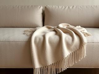 Plaid en laine naturelle posé sur un canapé